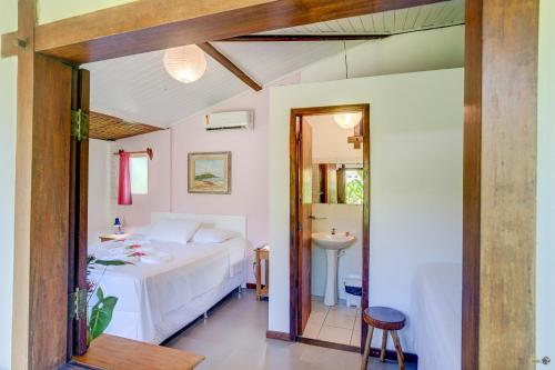 a bedroom with a bed and a sink in a room at Pousada Piratas in Itacaré