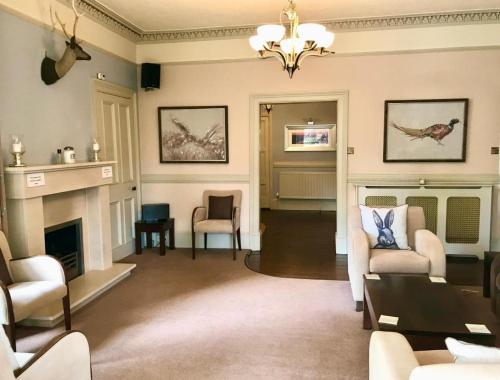 a living room with chairs and a fireplace at The Abbotsford in Callander