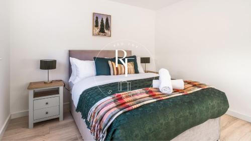 a bedroom with a bed with a green blanket at The Den at Catto in Peterhead