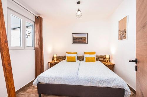 a bedroom with a large bed with yellow pillows at Casa da Courela do Olival - Santo Aleixo