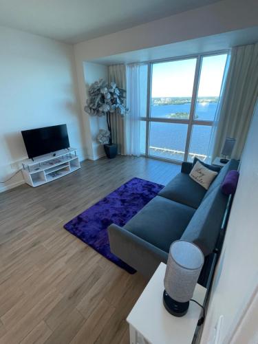 a living room with a blue couch and a large window at Riverview Penthouse in Fort Myers