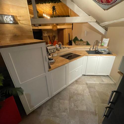 une cuisine avec des armoires blanches et un évier dans l'établissement Apartment Design Suite, à Jehanster