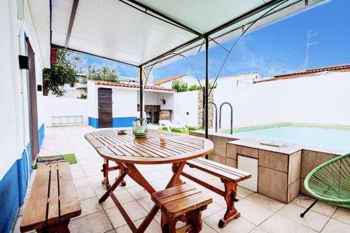 a patio with a table and chairs and a swimming pool at Casa da Courela do Olival - Santo Aleixo