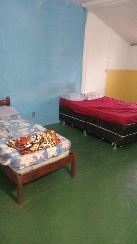 two beds sitting in a room with green floors at Marlon Franca in Salvador