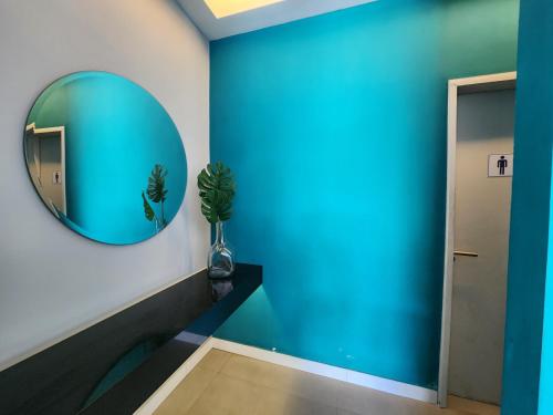 a hallway with a blue wall and a mirror at Encanto da Praia LUXO Ap 2 qts Pe na Areia Camboinhas in Niterói