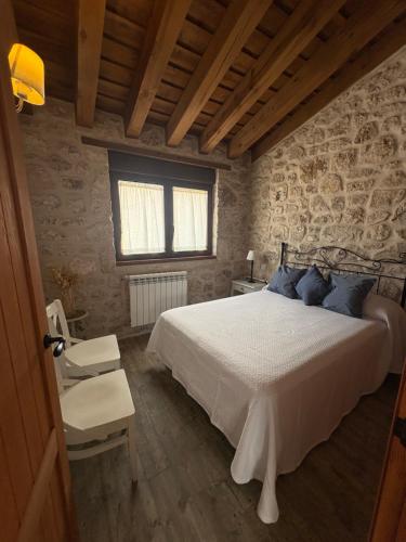 a bedroom with a large bed and a window at El Jardín de los Olivos in Fuentesaúco de Fuentidueña