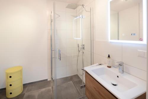 a white bathroom with a sink and a shower at Hermine, Black Forest Retreat, mit Sonnenterrasse in Baiersbronn