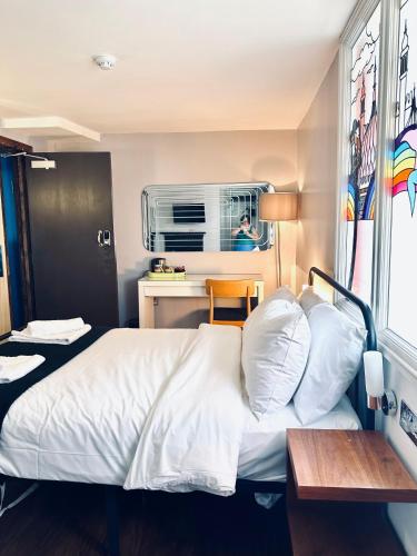 a bedroom with a bed and a desk and a window at Guest And The City in Brighton & Hove