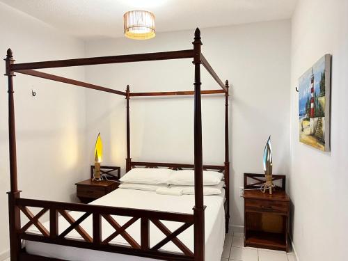 a bedroom with a canopy bed and two night stands at Villa Wiktor Paracuru in Paracuru