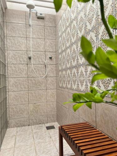 a bathroom with a shower with a bench in it at Villa Wiktor Paracuru in Paracuru