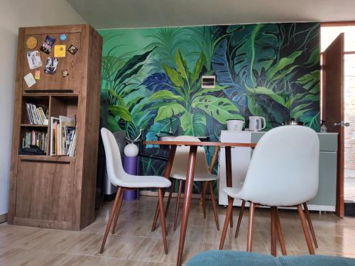 a dining room with a table and chairs with a mural at Casa hogareña Pequeña in Ica
