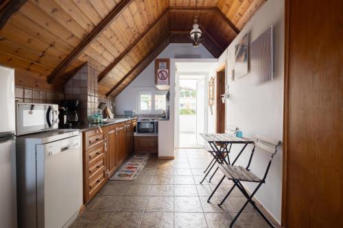 a kitchen with white appliances and a wooden ceiling at Myrto's Memories "My Sofitaki"- Seaview Studio in Melíssion