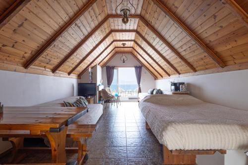 a bedroom with two beds and a wooden ceiling at Myrto's Memories "My Sofitaki"- Seaview Studio in Melíssion