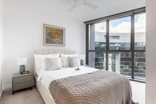 a bedroom with a bed and a large window at Gorgeous 3BR Apartment with Study overlooking BNE River in Brisbane
