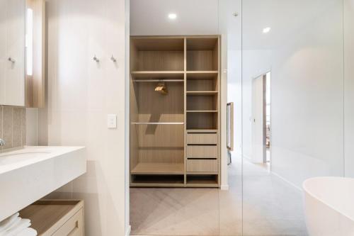 a bathroom with a walk in shower and a sink at Gorgeous 3BR Apartment with Study overlooking BNE River in Brisbane