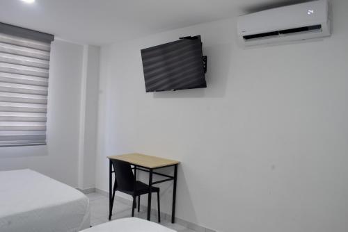 a room with a table and a chair and a bed at Hotel Casa Camoa in Villavicencio