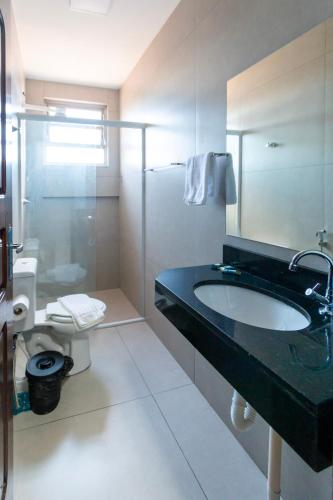 a bathroom with a sink and a shower and a toilet at GB Hotéis Foz Centro in Foz do Iguaçu