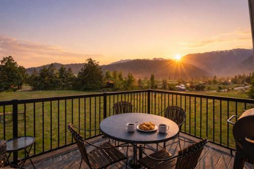 a table and chairs on a balcony with the sunset at Berg Haus Home in Leavenworth