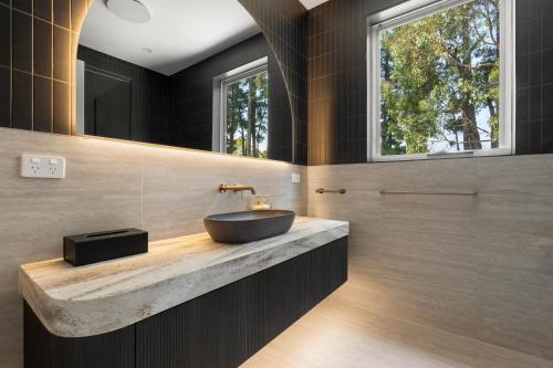 a bathroom with a sink and two windows at Mantons Creek Estate in Shoreham