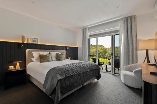 a hotel room with a bed and a balcony at Mantons Creek Estate in Shoreham
