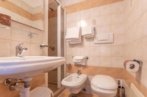 a white bathroom with a sink and a toilet at Hotel King in Rimini