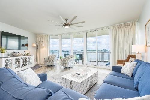 a living room with blue furniture and a large window at Caribe 305C by Youngs Suncoast in Orange Beach