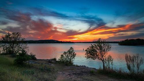 a sunset over a large body of water at Ranchette Apartment- beach access small lake view in Buchanan Dam