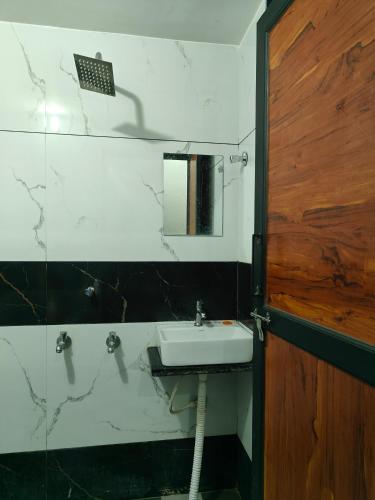 a bathroom with a sink and a mirror at Hotel Sudha Palace in Khātu