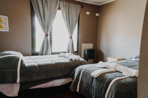 a bedroom with two beds and a window at Cabañas Lihuen in Caviahue