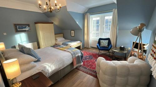 a bedroom with a large bed and a chair at The Cruachan Stoer in Stoer