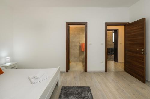a bathroom with a white counter and a wooden door at Villa Percan - Spacious Family Home with Private Pool on a 4000 Square Meter Plot in Krnica