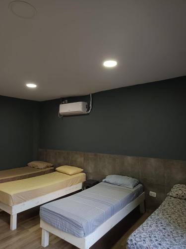 two beds in a room with a black wall at Residencia Dos Soles 2.0 in Resistencia