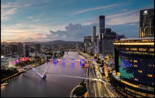 a view of a city with a bridge over a river at Queen's Wharf Apartments in Brisbane