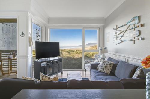 a living room with a couch and a large window at Oceanfront Condo King Suite & Pet-Friendly Stay in Rockaway Beach