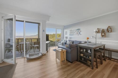 a living room with a couch and a table at Oceanfront Condo King Suite & Pet-Friendly Stay in Rockaway Beach