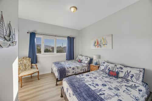 a bedroom with two beds and a window at Oceanfront Condo King Suite & Pet-Friendly Stay in Rockaway Beach