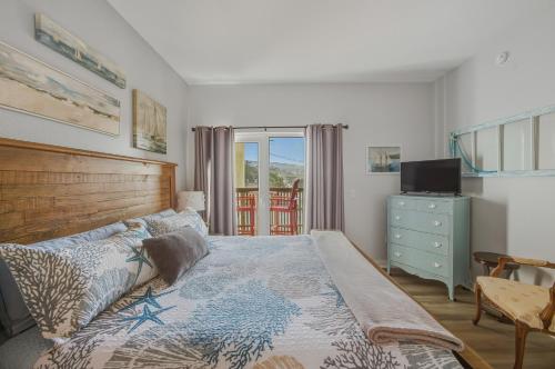 a bedroom with a bed and a dresser and a television at Oceanfront Condo King Suite & Pet-Friendly Stay in Rockaway Beach