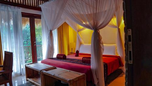 a bedroom with a canopy bed and a window at Kelimutu Crater Lakes Ecolodge in Kelimutu