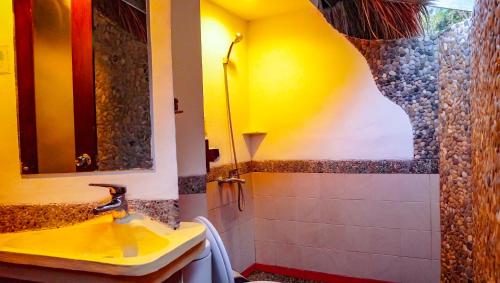 a bathroom with a yellow sink and a shower at Kelimutu Crater Lakes Ecolodge in Kelimutu