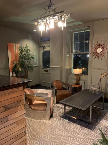 a living room with chairs and a table at Four Stars Hotel in London