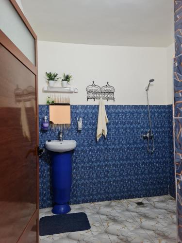 a bathroom with a blue tiled wall with a sink at Dar Benhoussa Imlil in Imlil