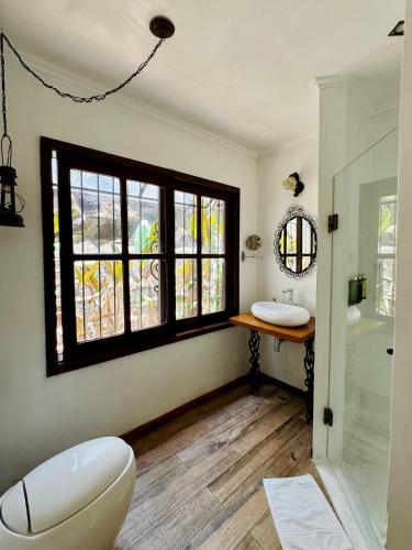 a bathroom with a toilet and a sink and a window at Rincón Escondido B&B in Puerto Iguazú