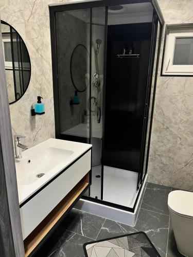 a bathroom with a shower and a white sink at Gora vitriv in Slavske
