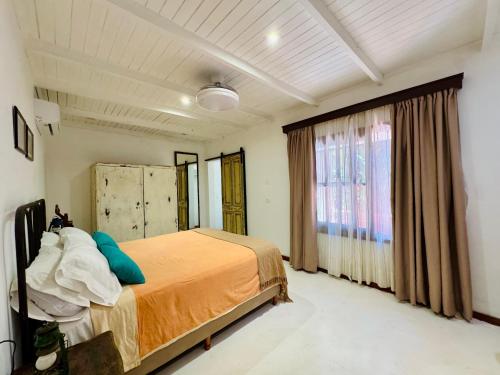 a bedroom with a bed and a large window at Rincón Escondido B&B in Puerto Iguazú