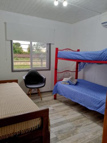 a room with two bunk beds and a chair at Casa Uno in Paso de la Patria