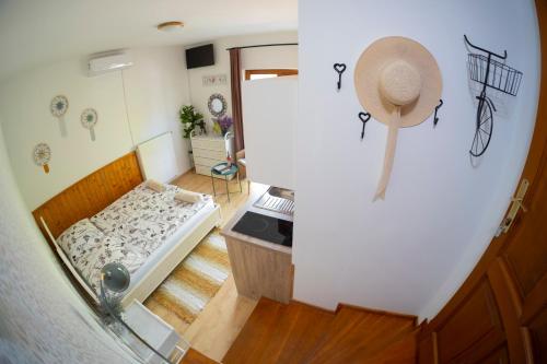 a small room with a bed and a hat on the wall at Vicze Apartmanház in Siófok