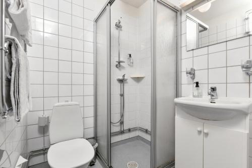 a bathroom with a shower and a toilet and a sink at Hotel Bema in Stockholm