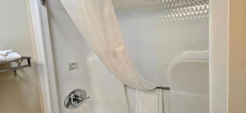 a shower with a white shower curtain in a bathroom at Grand Plaza Hotel & Conference Center in Branson