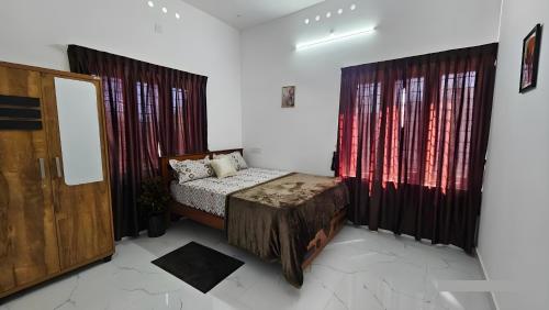 a bedroom with a bed and two windows at Beverly Hills Vagamon in Vagamon