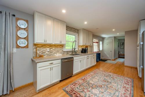 a kitchen with white cabinets and a rug on the floor at On Deep Creek Time by Railey Vacations in Friendsville